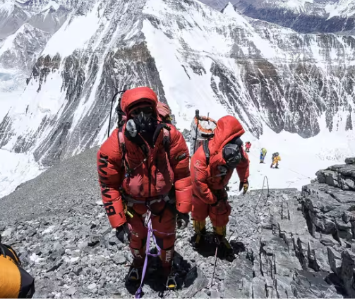 Alpinistes gravissant l'Everest équipés de masques et bouteilles