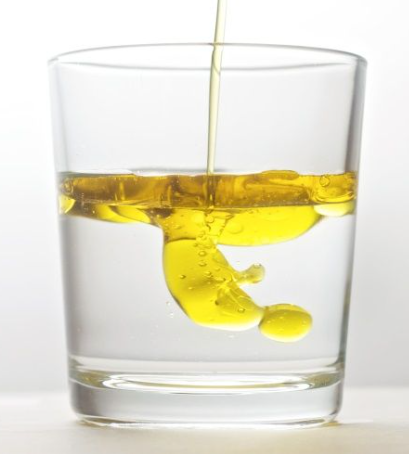 Verre montrant un mélange hétérogène d'eau et d'huile en deux couches